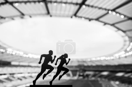 Foto de Siluetas de corredores masculinos y femeninos muestran dedicación y sinergia, trascendiendo límites en un estadio deportivo moderno - Imagen libre de derechos