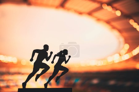 Foto de Persiguiendo la grandeza juntos: Siluetas de corredores masculinos y femeninos empujan los límites, inspirándose unos a otros en un estadio deportivo moderno. - Imagen libre de derechos