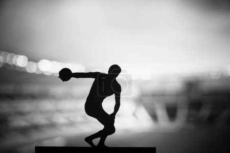 Foto de Silueta de Atleta, Lanzando el Disco en medio de la Atmósfera Vespertina Eterna. Foto de pista y campo para los Juegos de Verano en París. - Imagen libre de derechos