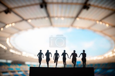 Téléchargez les photos : La silhouette de six sprinteurs illumine la piste du stade moderne. Athlétisme Jeux d'été 2024 à Paris. - en image libre de droit