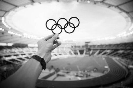 Foto de PARÍS, FRANCIA, 7 DE JULIO DE 2023: El atleta sostiene el símbolo de los anillos olímpicos con orgullo. Foto para los Juegos Olímpicos de París 2024. - Imagen libre de derechos