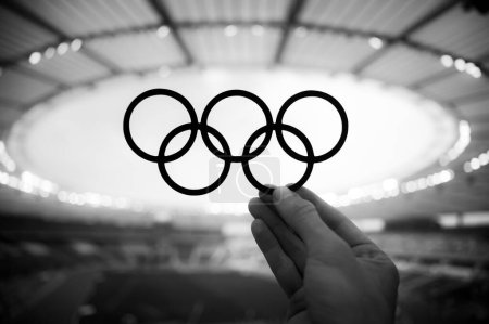 Foto de PARÍS, FRANCIA, 7 DE JULIO DE 2023: Conexión simbólica: La mano del atleta cumple con los anillos olímpicos, reflejando los Juegos Olímpicos de Verano en París 2024 - Imagen libre de derechos