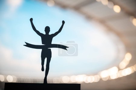 Téléchargez les photos : Finition exaltante : Silhouetted Runner revendique la victoire au stade d'athlétisme moderne. Modifier Espace, Athlétisme Compétition Photo - en image libre de droit