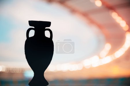 Téléchargez les photos : Silhouette du trophée européen de football rayonnant en splendeur du soir. Photo pour Football Europe Tournament. Modifier l'espace pour votre Montage - en image libre de droit