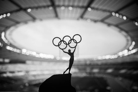 Foto de PARÍS, FRANCIA, 7 DE JULIO DE 2023: Foto en blanco y negro. Olympic Spirit: Statue of Athlete Holds Olympic Circle High at Modern Olympic Stadium (en inglés). Captura de la esencia de los Juegos Olímpicos de París 2024. - Imagen libre de derechos