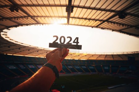 Téléchargez les photos : 2024 Année Athlète sur le stade moderne. Un aperçu de l'avenir : la silhouette du signe '2024', symbole de l'année sportive et des Jeux d'été à Paris - en image libre de droit
