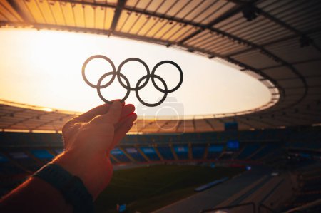 Foto de PARÍS, FRANCIA, 7 DE JULIO DE 2023: Revelando el emblema: El atleta presenta los anillos olímpicos en majestuoso resplandor vespertino. Foto para los Juegos Olímpicos de París 2024. - Imagen libre de derechos