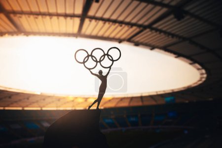 Photo for PARIS, FRANCE, JULY 7, 2023: Symbolic Power: Statue of Athletic Woman Raises Olympic Circle at Modern Olympic Stadium. Sport Photo for Paris 2024 Summer Olympic Games. - Royalty Free Image