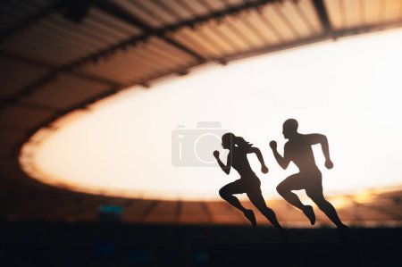 Foto de Running as One: Siluetas de corredores masculinos y femeninos se unen, mezclando elegantemente sus energías frente a un estadio deportivo moderno - Imagen libre de derechos