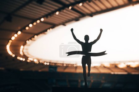 Photo for Conquering the Finish Line: Silhouetted Runner's Victory Stirs the Atmosphere at Modern Athletics Stadium. A Compelling Image of Track and Field Triumph. Warm color Tone photo for Summer in Paris 2024 - Royalty Free Image