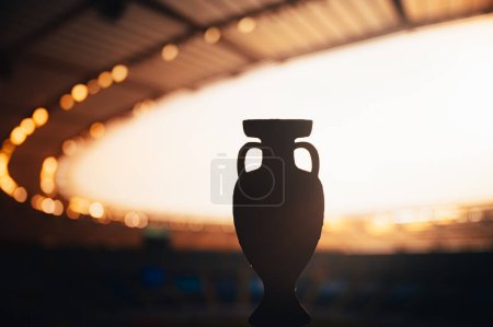Téléchargez les photos : Silhouette de European Football Trophy Glistening au Modern Stadium. Photo pour Football Europe Tournament. Modifier l'espace pour votre Montage - en image libre de droit