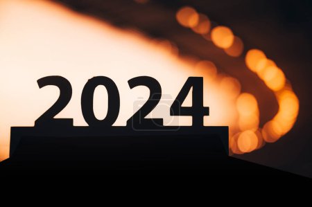 Téléchargez les photos : Année de l'excellence athlétique : la silhouette du signe '2024' brille contre le ciel crépusculaire. Année sportive. Jeux d'été à Paris. - en image libre de droit