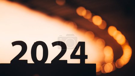Photo for Silhouette of '2024' Sign Guides the Way to Summer Games in Paris. Sports Year Unveiled. Warm Summer sunset light in background. - Royalty Free Image