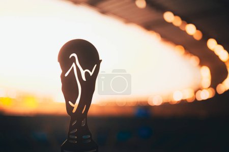 Téléchargez les photos : Silhouette du Trophée Mondial de Football Brillant au Crépuscule. Photo pour le Tournoi du Monde de Football. Modifier l'espace pour votre Montage - en image libre de droit