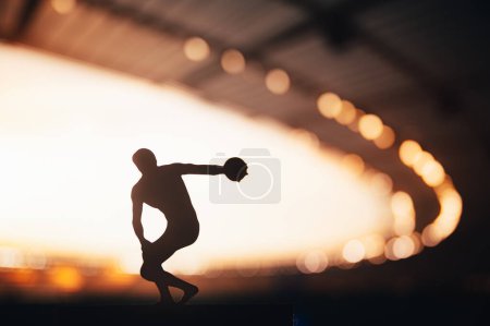 Photo for Silhouette of Athlete, Discus Soaring in the Breathtaking Evening Glow. Track and Field Photo for Summer Games in Paris. - Royalty Free Image