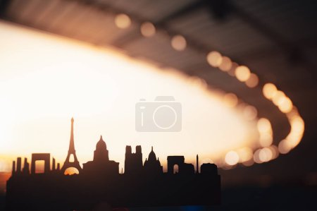 Téléchargez les photos : La silhouette majestueuse de Paris : une grandeur alléchante pour les Jeux sportifs de 2024. Stade comme toile de fond, baigné dans la lueur chaude d'un lever de soleil glorieux - en image libre de droit