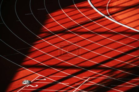 Téléchargez les photos : Une vue fascinante de la piste rouge, ornée de lignes blanches immaculées et de chiffres - Illustration d'athlétisme Photo pour les mondes à Budapest et Jeux à Paris - en image libre de droit