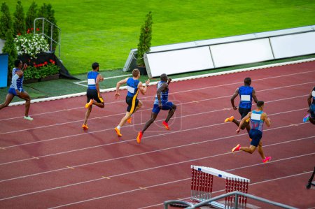 Photo for Men's 100m Sprint Race Commencement at a Track and Field Event: Athletes in Action on the Running Track. Track and field photo for Worlds in Budapest and Games in Paris - Royalty Free Image