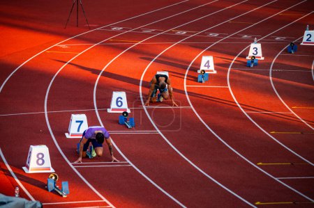 Photo for Sprinters Ready to Begin the 200m Race, Captured at the Precise Moment of Starting Blocks Setup - Track and Field Illustration Photo for Worlds in Budapest and Games in Paris - Royalty Free Image