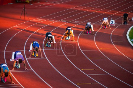 Téléchargez les photos : Les athlètes se positionnent aux blocs de départ pour le début de la course au sprint de 200 m sur la piste de course Illustration d'athlétisme Photo pour les championnats du monde à Budapest et les Jeux à Paris - en image libre de droit