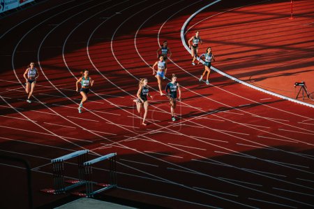 Foto de OSTRAVA, CZECHIA, 27 DE JUNIO DE 2023: 400m Carrera femenina negociando curva con dinámica de luz y sombra en pista y campo para mundos en Budapest y juegos olímpicos de verano en París - Imagen libre de derechos