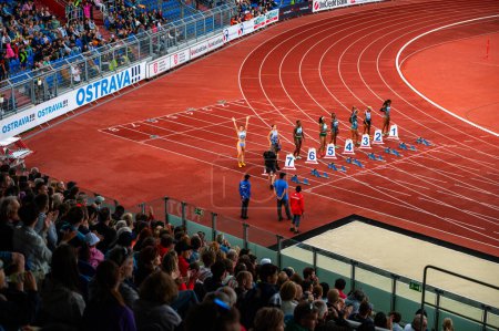 Foto de OSTRAVA, CZECHIA, 27 DE JUNIO DE 2023: Sprinters femeninas a 100m Línea de inicio de carrera de obstáculos en pista y campo para mundiales en Budapest y juegos en París - Imagen libre de derechos