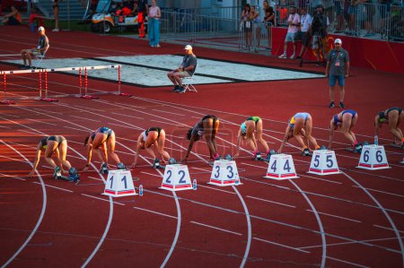 Foto de B. BYSTRICA, ESLOVAQUIA, 20 DE JULIO DE 2023: Atletas femeninas inician un sprint de 100m a partir de bloques iniciales en pista y campo para mundos en Budapest y juegos olímpicos de verano en París - Imagen libre de derechos