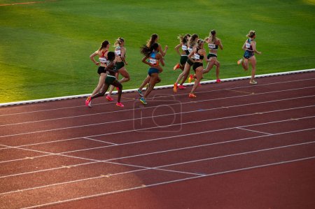 Photo for B. BYSTRICA, SLOVAKIA, JULY 20, 2023: Spectacular Sunset Scene: Female Runners Engage in 800m Race with Poise in Enchanting Dusk Setting at Track and Field Meet for Worlds in Budapest. Games in Paris - Royalty Free Image