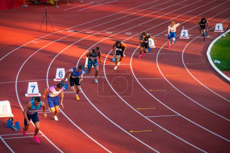 Foto de B. BYSTRICA, ESLOVAQUIA, 20 DE JULIO DE 2023: Hombres Sprinters listos para la carrera de 200m, rodeados por la luz dorada de la noche, en el concurso de atletismo y atletismo para los Mundos de Budapest y los Juegos Olímpicos de Verano en París - Imagen libre de derechos