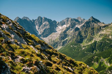 Photo for High Tatras rising like giants from the gentle slopes of the Belianske Tatras, set against a backdrop of pure blue skies - Royalty Free Image