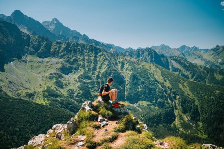 Photo for Embracing the beauty of the Belianske Tatras, a young traveler revels in serenity, all while the High Tatras' grandeur unfolds in the backdrop - Royalty Free Image