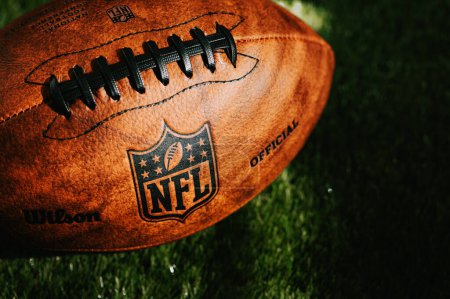 Téléchargez les photos : NEW YORK, USA, 11 SEPTEMBRE 2023 : Photo de fond de la NFL. Balle placée sur l'herbe verte dans une belle lumière. - en image libre de droit