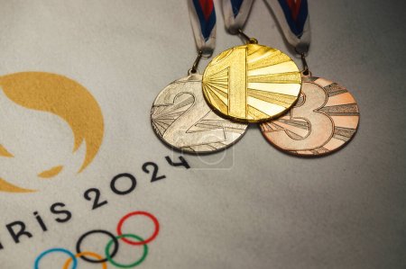 Foto de PARÍS, FRANCIA, ENERO 4. 2024: Exhibición exclusiva: Logo oficial de los Juegos Olímpicos de París 2024 en manta blanca con medallas de oro, plata y bronce - Imagen libre de derechos