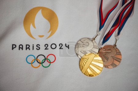 Photo for PARIS, FRANCE, JANUARY 4. 2024: Paris 2024 Summer Games Memorabilia: White Blanket Presentation of Gold, Silver, and Bronze Medals with Official Logo - Royalty Free Image
