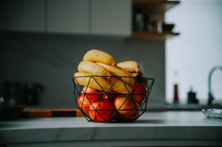 Téléchargez les photos : Banane et pommes sur le comptoir de la cuisine, baignées dans la chaleur du jour - en image libre de droit