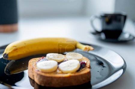 Téléchargez les photos : Matin bien équilibré : un petit déjeuner nutritif tartiné d'une banane et de pain aux grains entiers - en image libre de droit