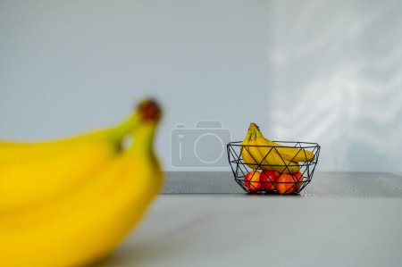 Sunlight bathes a banana in a glass bowl on the kitchen counter
