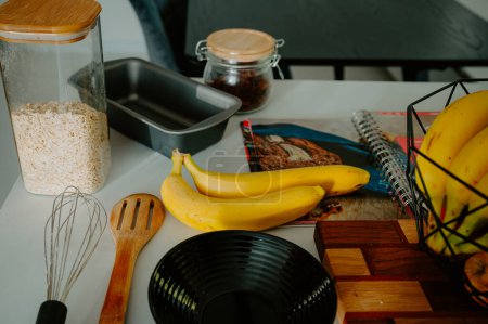 Gearing up for baking success: Fresh banana, pot, and cookbook in frame