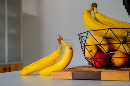 Téléchargez les photos : Banane sur le comptoir de la cuisine, embrassée par la lumière naturelle - en image libre de droit