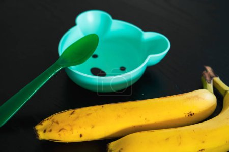 Téléchargez les photos : Banane et bol pour bébé en forme d'ours. Nourrir un bambin de fruits - en image libre de droit