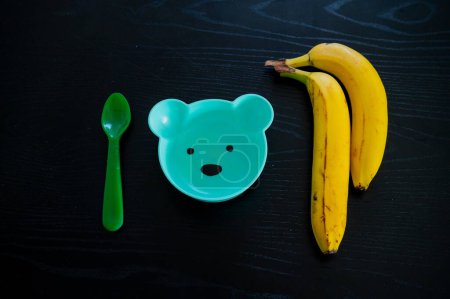 Téléchargez les photos : Banane et bol pour bébé en forme d'ours. Nourrir un bambin de fruits - en image libre de droit