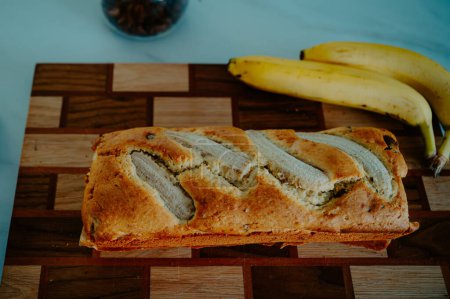 Photo for Natural light highlights a banana bread and fresh banana on the kitchen surface - Royalty Free Image