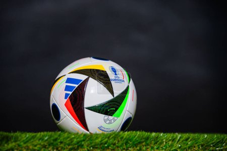 Téléchargez les photos : LEIPZIG, ALLEMAGNE, 17 AVRIL 2024 : Ballon officiel de football Adidas Fussballliebe pour le tournoi de football Euro 2024, placé sur l'herbe verte. Fond noir, éditer l'espace Tournoi européen en Allemagne - en image libre de droit