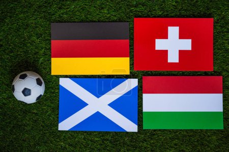 Téléchargez les photos : Groupe A au tournoi de football européen en Allemagne en 2024. Drapeaux d'Allemagne, d'Écosse, de Hongrie, de Suisse et ballon de football sur herbe verte - en image libre de droit