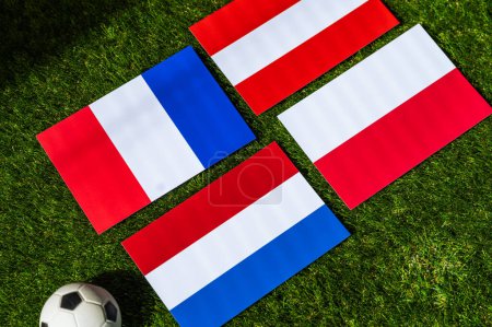 Poland Heads Group D: Flags of Poland, Netherlands, Austria, France, and soccer ball on green grass at Europe football tournament in Germany in 2024