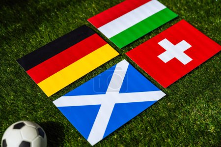 Grupo A en el torneo de fútbol europeo en Alemania en 2024. Banderas de Alemania, Escocia, Hungría, Suiza y pelota de fútbol sobre hierba verde