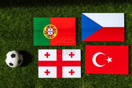 Grupo F en el torneo de fútbol europeo en Alemania en 2024. Banderas de Turquía, Georgia, Portugal, República Checa y pelota de fútbol sobre hierba verde