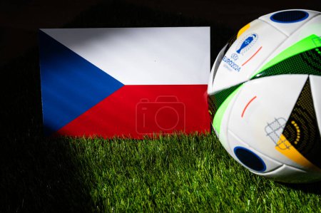 Photo for LEIPZIG, GERMANY, APRIL 17, 2024: Czech Republic national flag and official soccer ball of Euro 2024 football tournament in Germany placed on green grass. Black background, edit space - Royalty Free Image