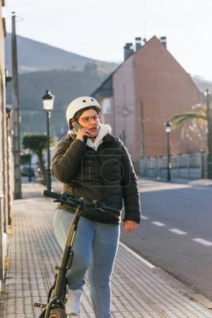 Foto de Mujer hispana viajando en bicicleta electrónica, cruzando una cuadra de la ciudad - Imagen libre de derechos