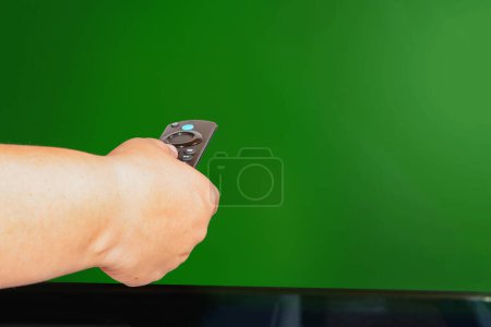 Foto de Control remoto apuntado a la televisión con prensa derecha aislada sobre fondo verde. - Imagen libre de derechos